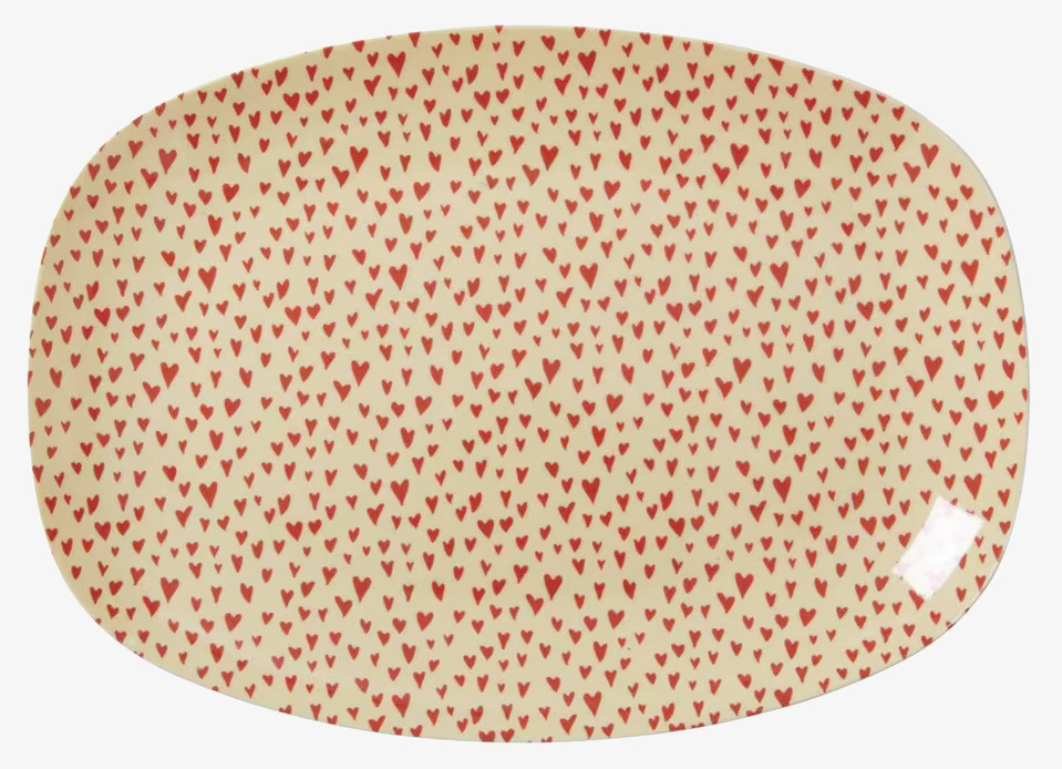 Liten Tallrik Hjärtan från Rice med röda hjärtan på ljus bakgrund