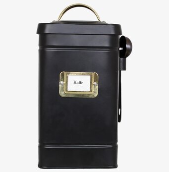 Foto av stilren svart kaffeburk med mässingsdetaljer