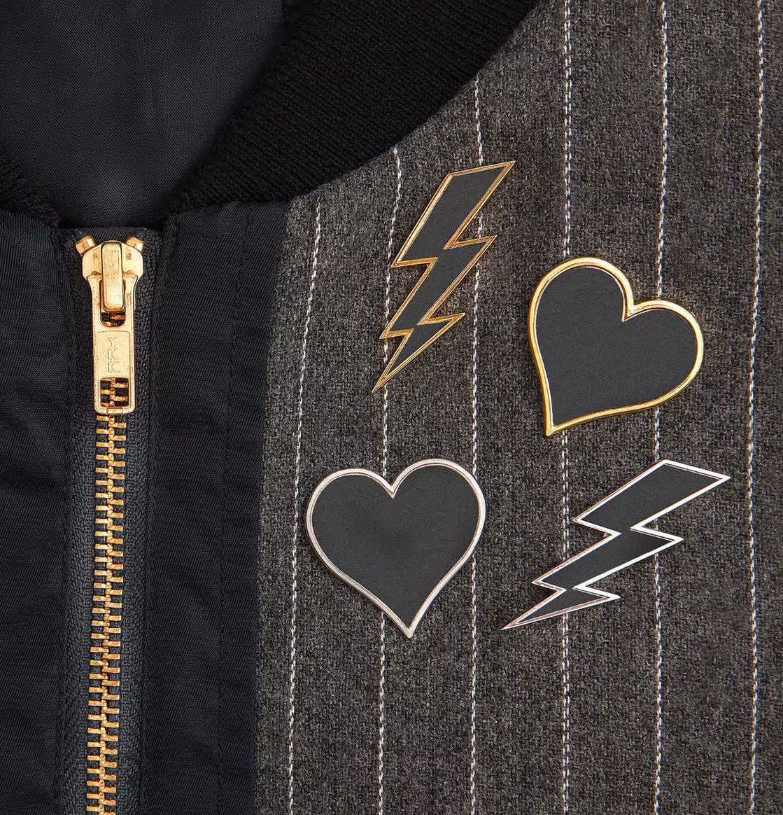 Reflex Pins Guld från Firefly på mörk jacka med dragkedja