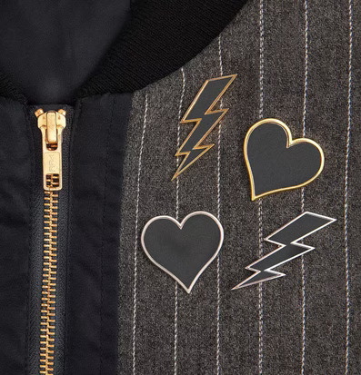 Reflex Pins Guld från Firefly på mörk jacka med dragkedja