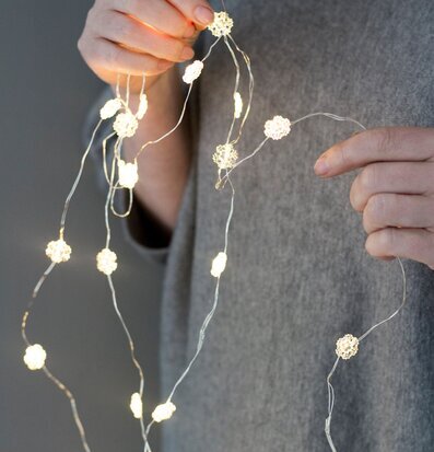 Ljusslinga Stjärna-Snöflinga från Storefactory hålls i händer