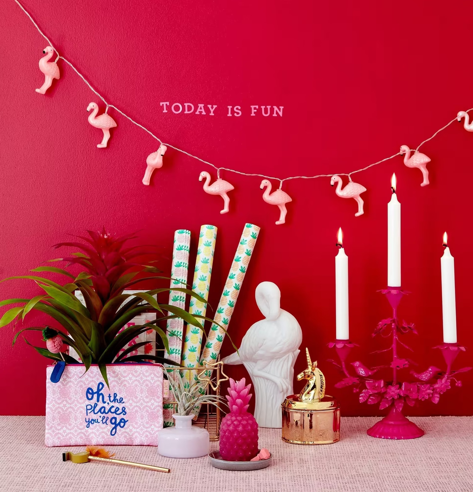 Ljusslinga LED Flamingo från Rice mot röd vägg med dekorationer