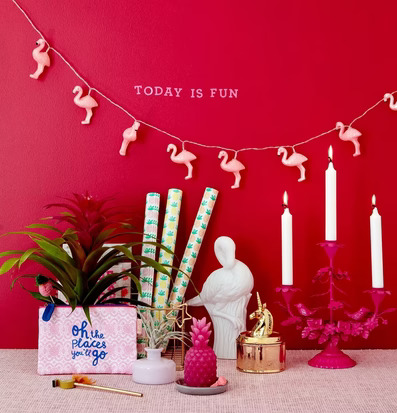 Ljusslinga LED Flamingo från Rice mot röd vägg med dekorationer