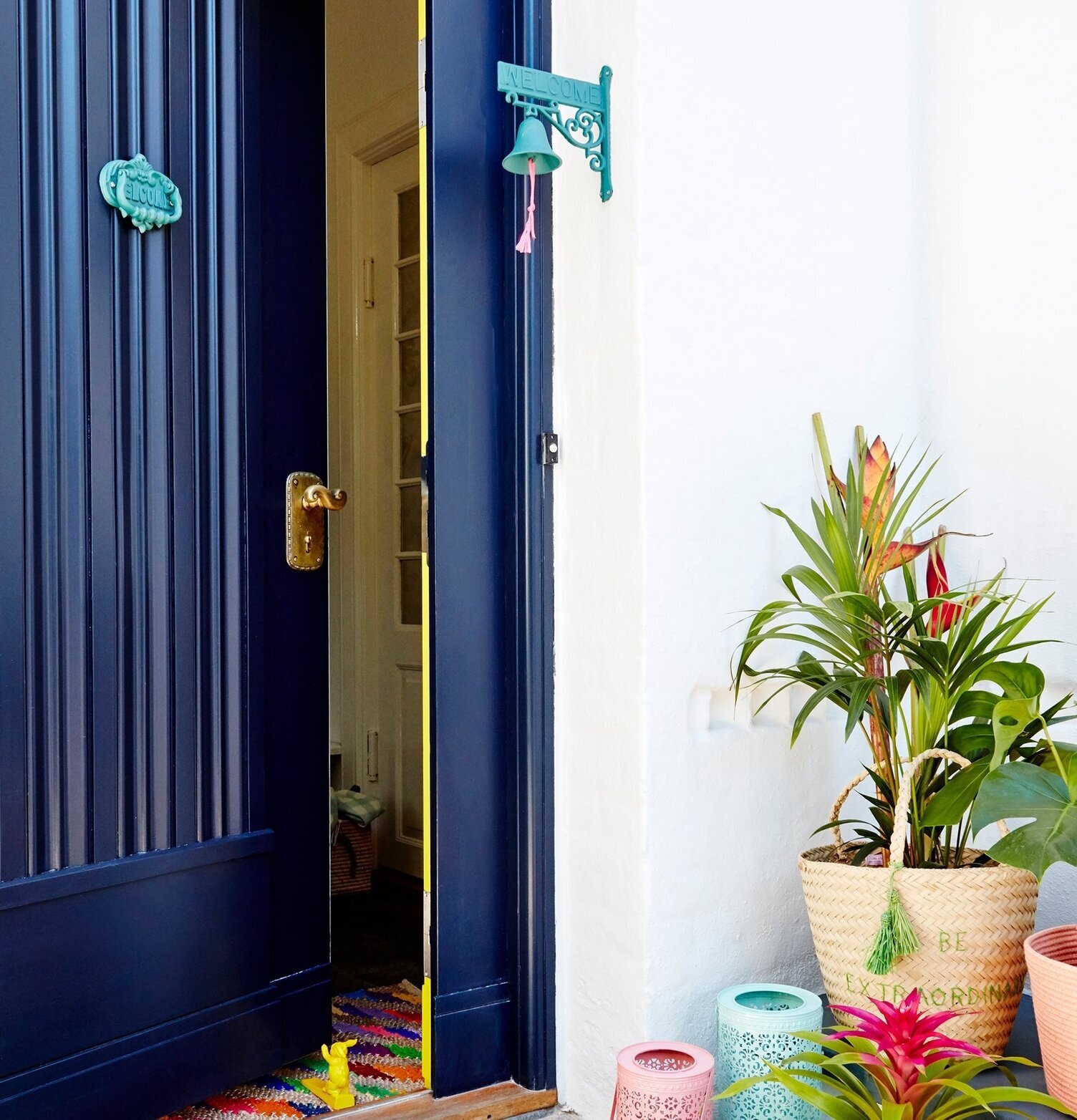 Dörrklocka Gul från Rice monterad bredvid en blå dörr