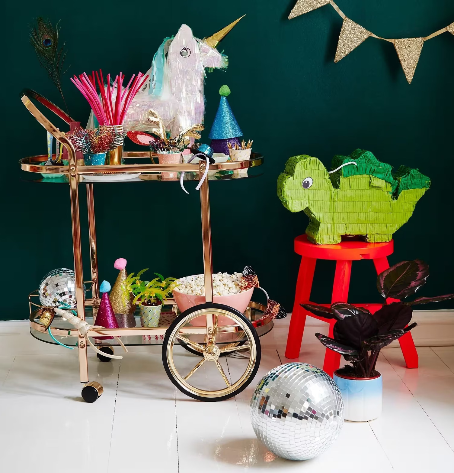 Pinata Dinosaurie från Rice på röd pall med festdekorationer