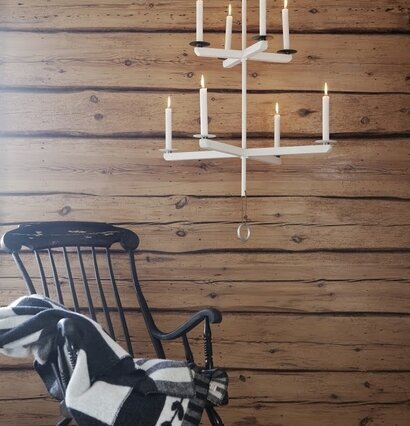 Ljuskrona Vit från Ernst hängande över en mörk trä gungstol