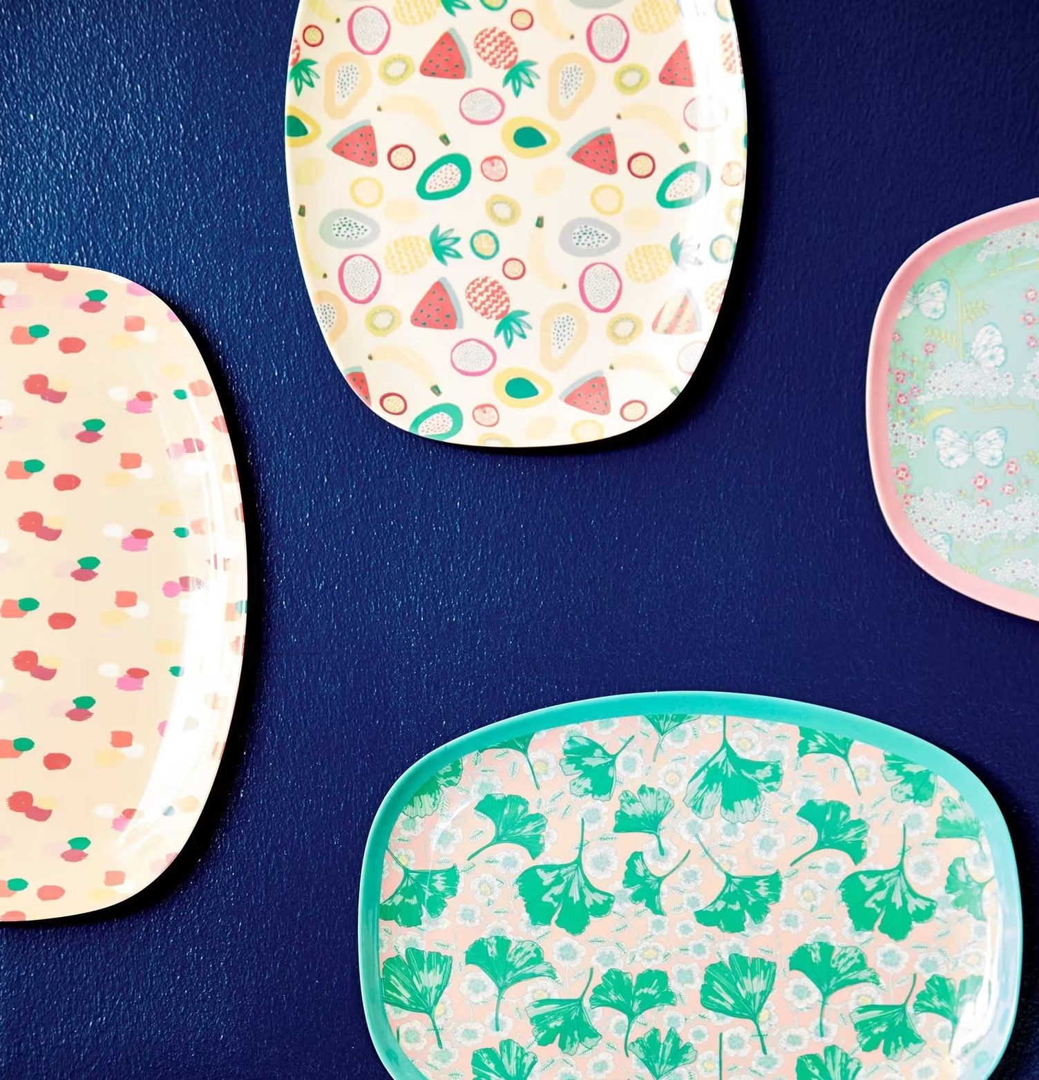 Tallrik TuttiFrutti print från Rice hänger på mörkblå vägg