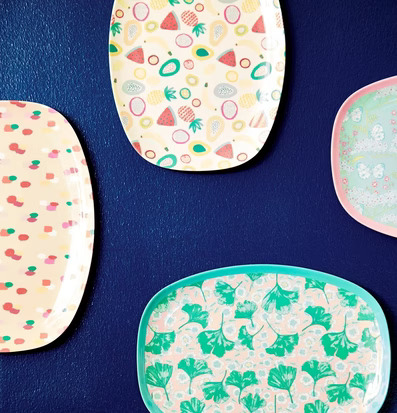 Tallrik TuttiFrutti print från Rice hänger på mörkblå vägg